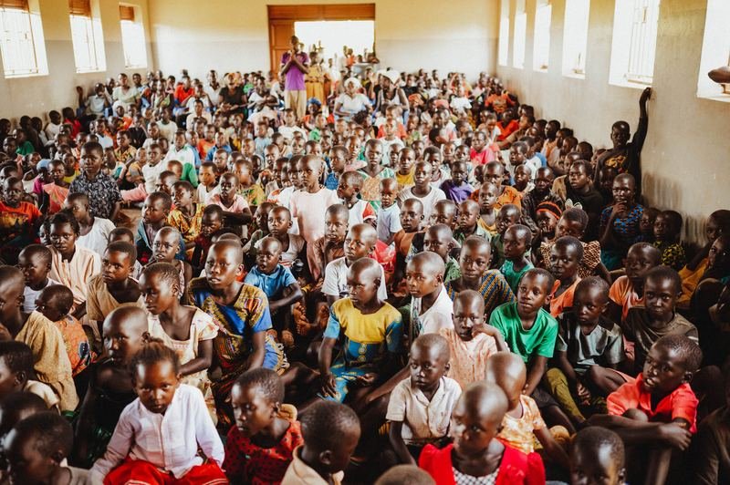 A room packed with children and adults gathered for a service