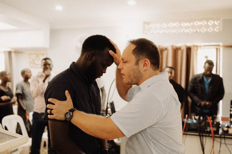 Laying hands on a man in prayer